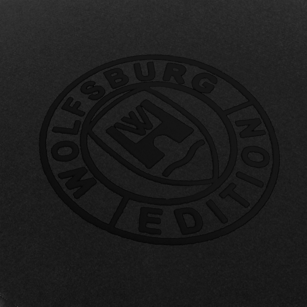 Das Wolfsburg Editions Logo auf einem schwarzen Teppich und das Logo ist in schwarz.